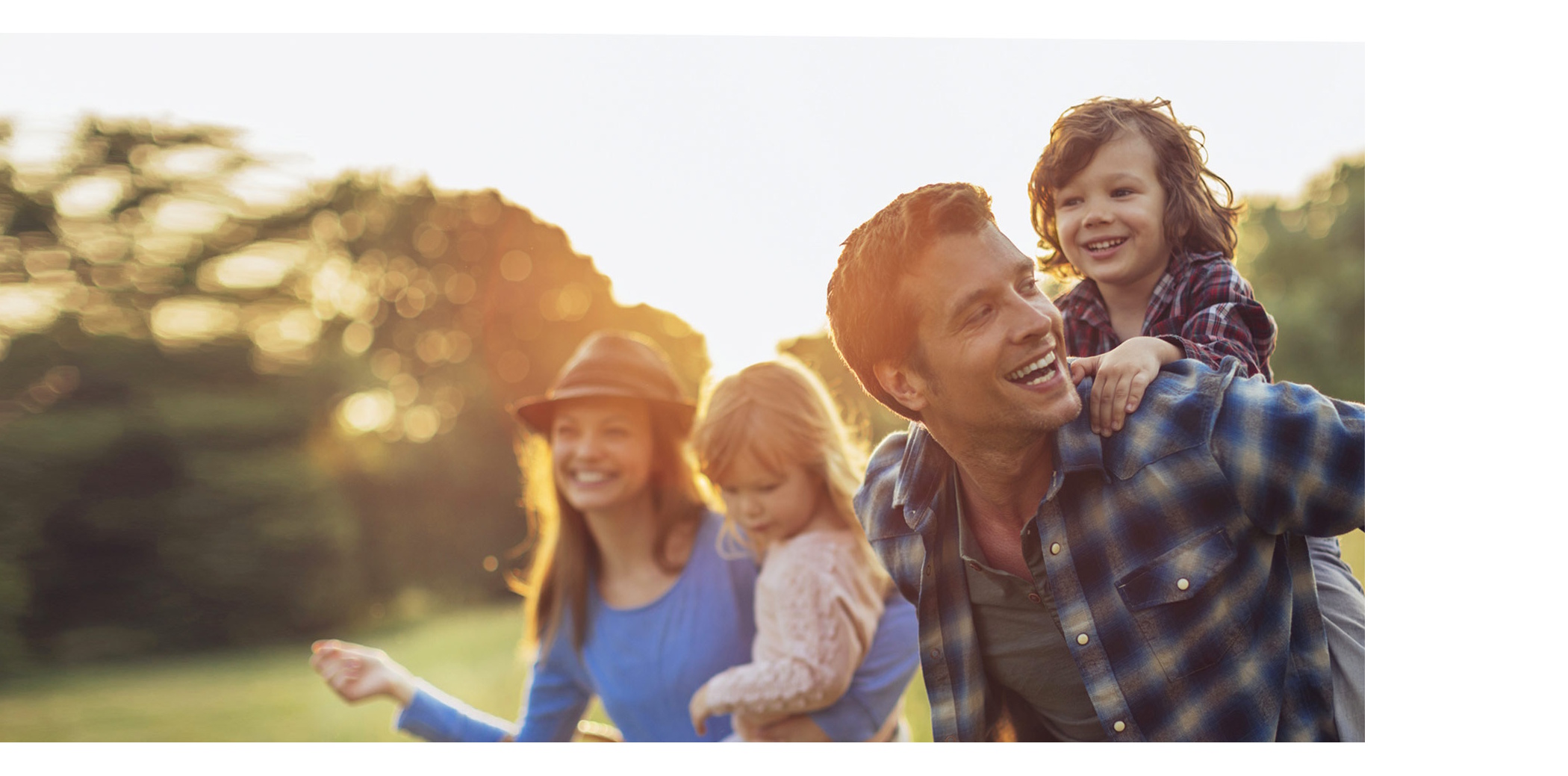 Family playing together in the field during the sun setting
