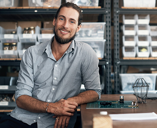 Confident business owner leaning on a table