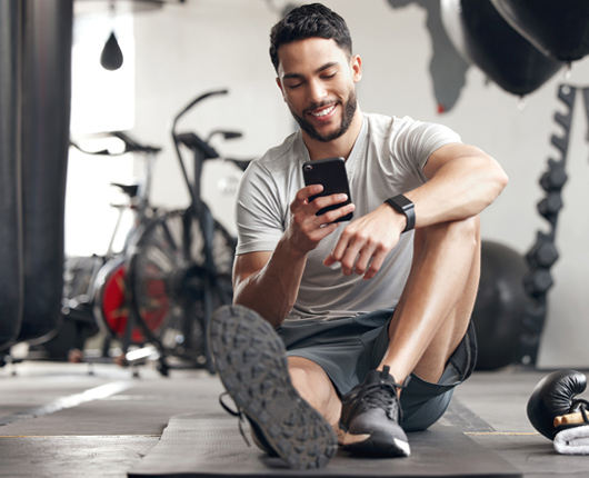 Man using smart phone at the gym.