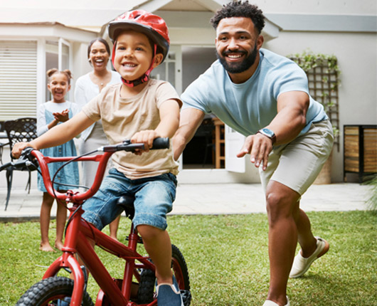 Man pushing child on bike